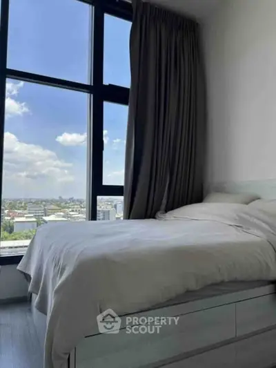 Modern bedroom with large window offering stunning city view