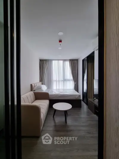 Modern bedroom with cozy sofa and stylish decor, perfect for urban living.