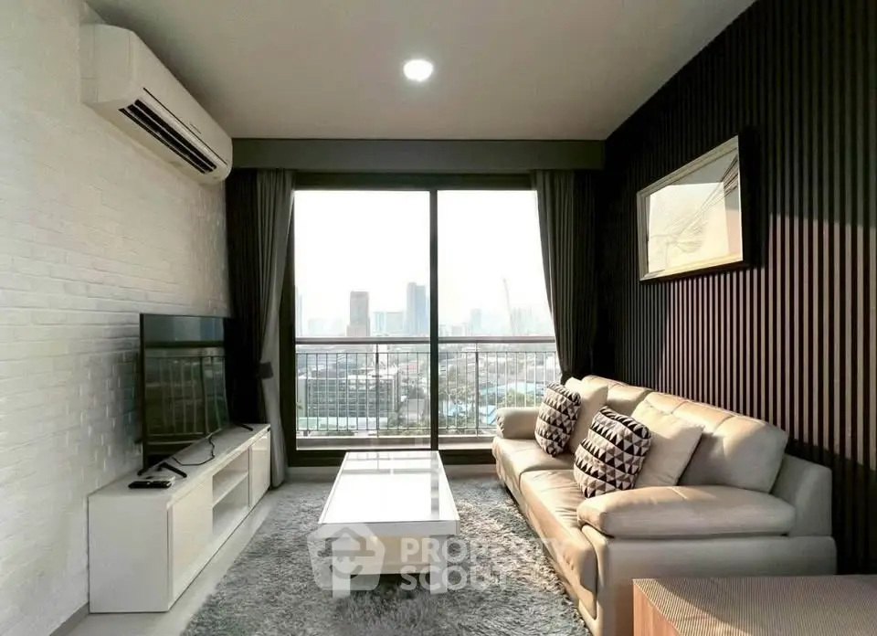 Modern living room with city view, featuring sleek furniture and large windows for natural light.