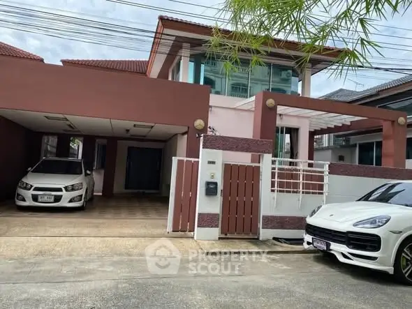 Modern two-story house with carport and luxury vehicles in driveway