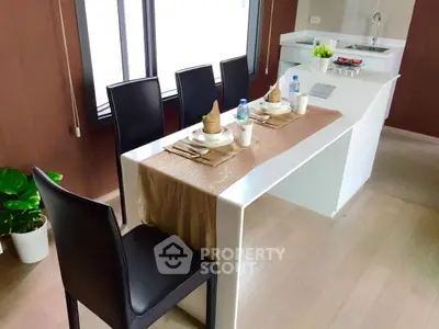 Modern kitchen with sleek dining area and elegant table setting in a stylish apartment.