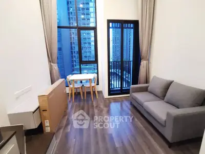 Modern living room with city view, featuring sleek furniture and floor-to-ceiling windows.