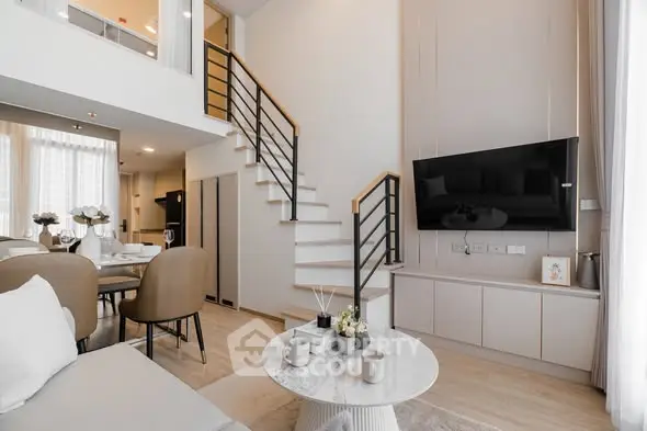 Modern duplex living room with stylish decor and open staircase