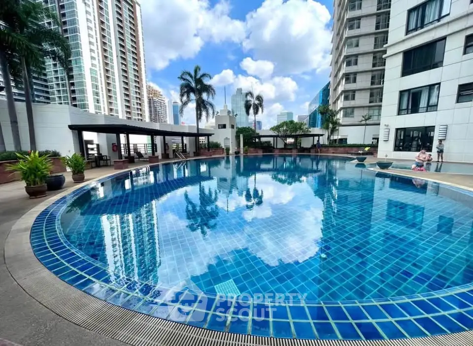Luxurious high-rise building with stunning pool and city views, perfect for urban living.