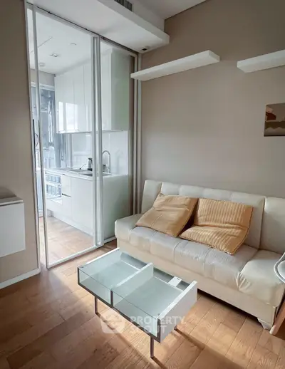 Modern living room with glass partition and sleek kitchen view