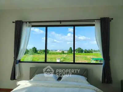 Bright bedroom with large window offering stunning countryside view