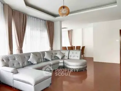 Spacious modern living room with elegant sectional sofa and large windows.