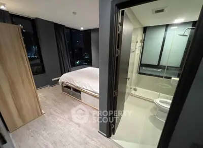 Modern bedroom with ensuite bathroom featuring sleek design and city view.