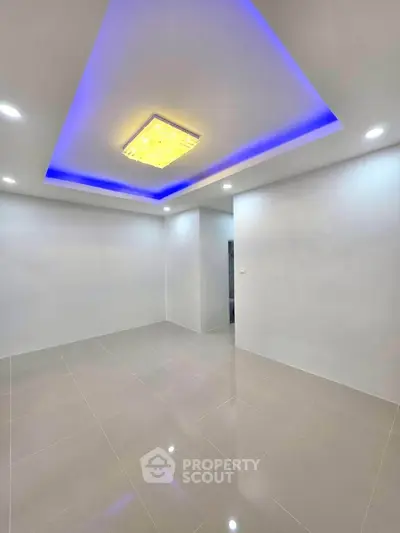Modern minimalist living room with sleek tile flooring and ambient ceiling lighting.