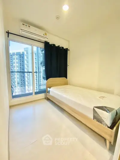 Cozy bedroom with single bed and balcony view in modern apartment