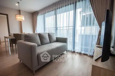 Modern living room with large windows and stylish furniture in a bright apartment.