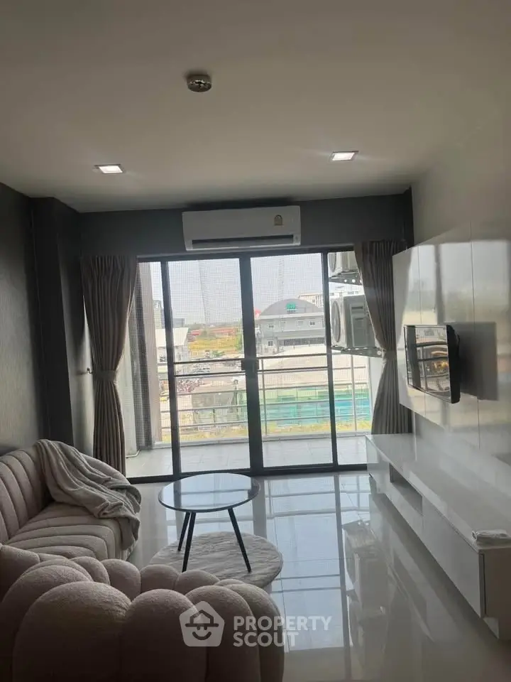 Modern living room with stylish furniture and large windows offering a city view.