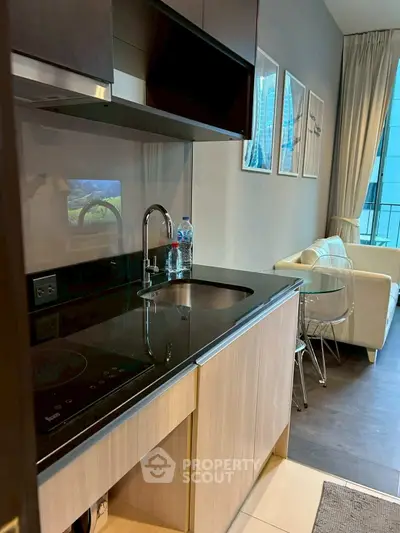 Modern kitchen with sleek design and cozy living area in a stylish apartment.