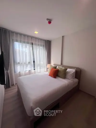 Cozy bedroom with modern decor and large window for natural light