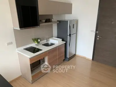 Modern compact kitchen with sleek appliances and wooden cabinetry