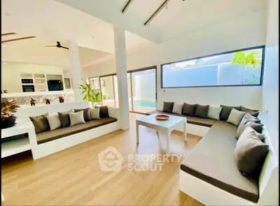 Spacious modern living room with pool view and elegant seating area