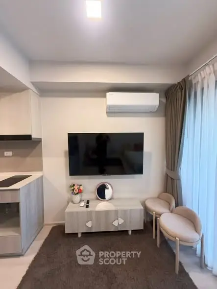 Modern living room with wall-mounted TV, air conditioning, and stylish furniture in a cozy apartment.