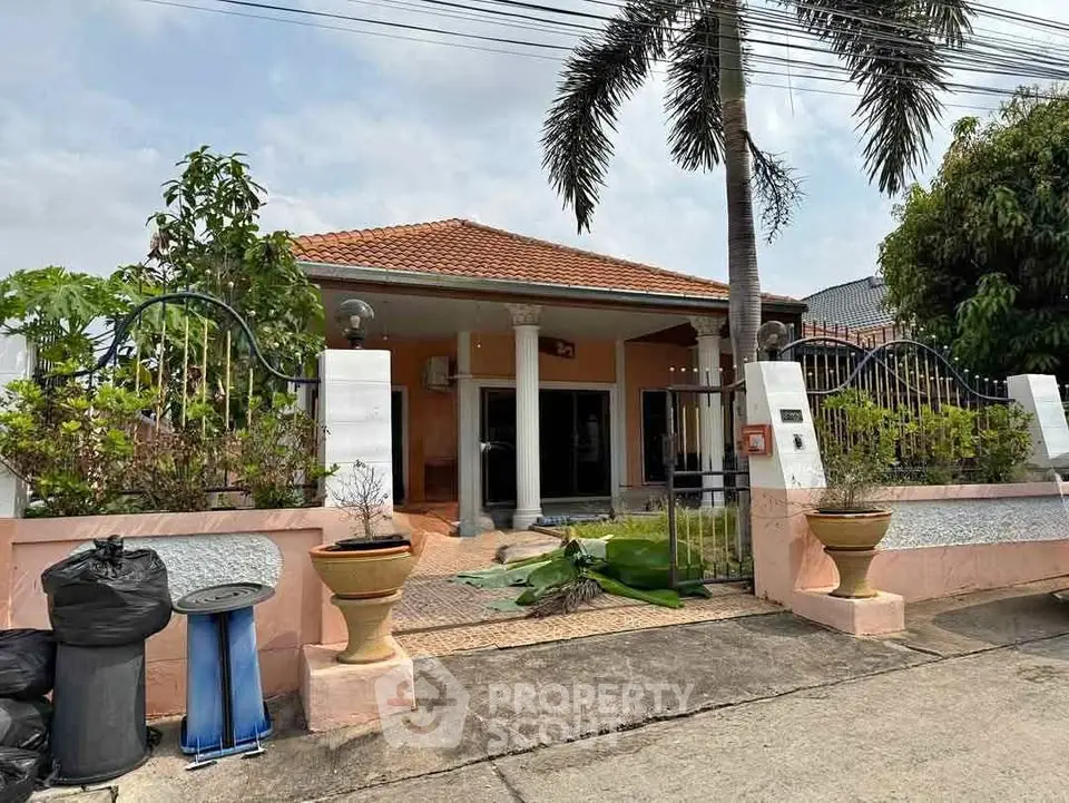 Charming single-story home with tiled roof and lush garden in a serene neighborhood.