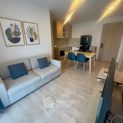 Modern living room with open kitchen, stylish decor, and cozy seating area.