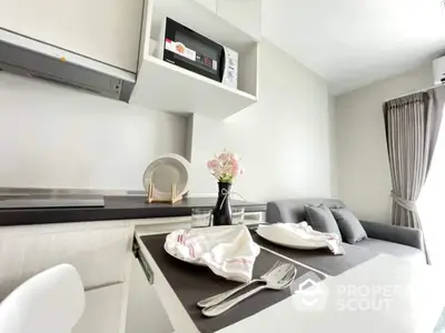 Sleek modern kitchen with built-in microwave, stylish cabinetry, and a cozy dining nook perfect for intimate meals.