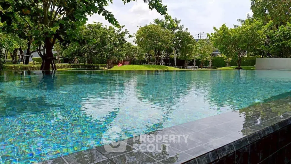 Luxurious infinity pool surrounded by lush greenery in a serene residential setting.