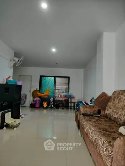 Spacious living room with modern decor and ample natural light, perfect for family gatherings.