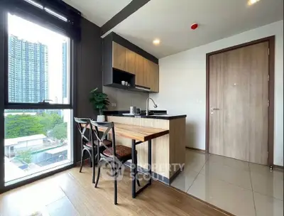 Modern kitchen with open layout and city view, featuring sleek cabinetry and dining area.