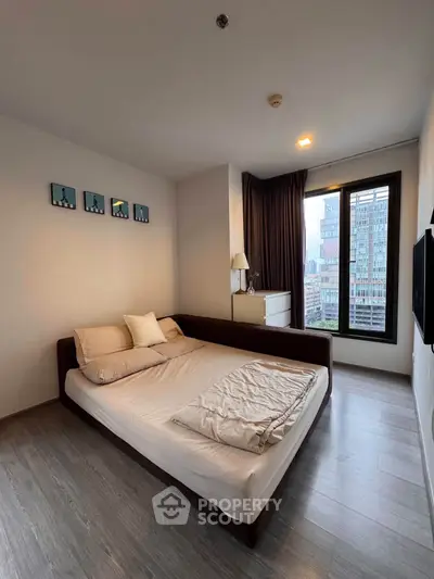 Modern bedroom with city view, featuring sleek design and natural light.