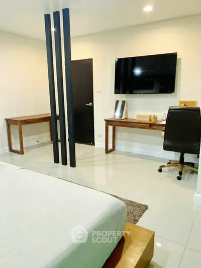 Modern bedroom with sleek furniture and wall-mounted TV, ideal for contemporary living.