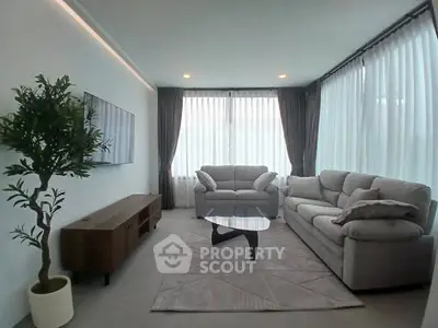 Modern living room with stylish furniture and large windows for natural light.