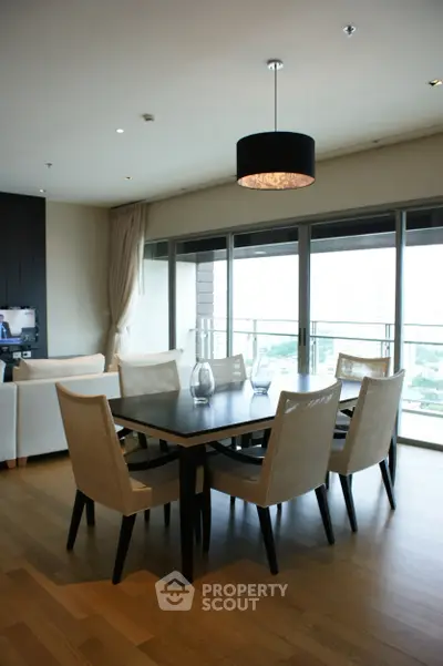 Spacious dining area with elegant furniture and large windows offering a stunning view.
