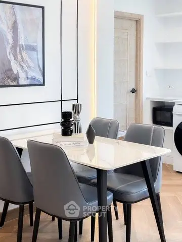 Modern dining area with sleek furniture and integrated laundry space in stylish apartment.