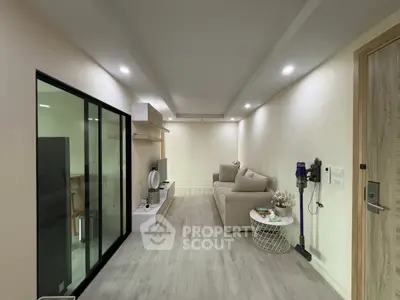 Modern living room with sleek design and neutral tones, featuring a cozy sofa and entertainment unit.