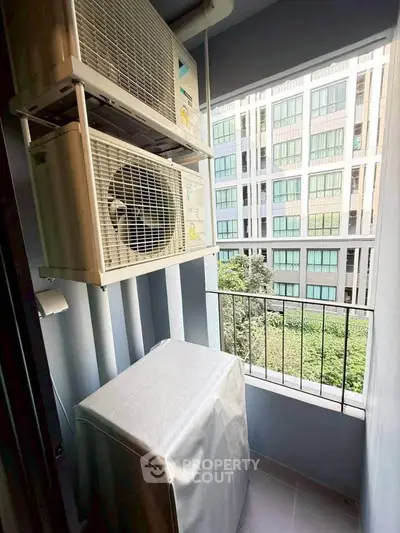 Compact balcony with air conditioning units and city view