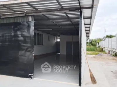 Spacious industrial-style garage with metal roof and open layout, perfect for storage or workshop use.
