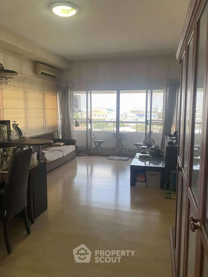 Spacious living room with large windows and balcony access, offering a bright and airy atmosphere.