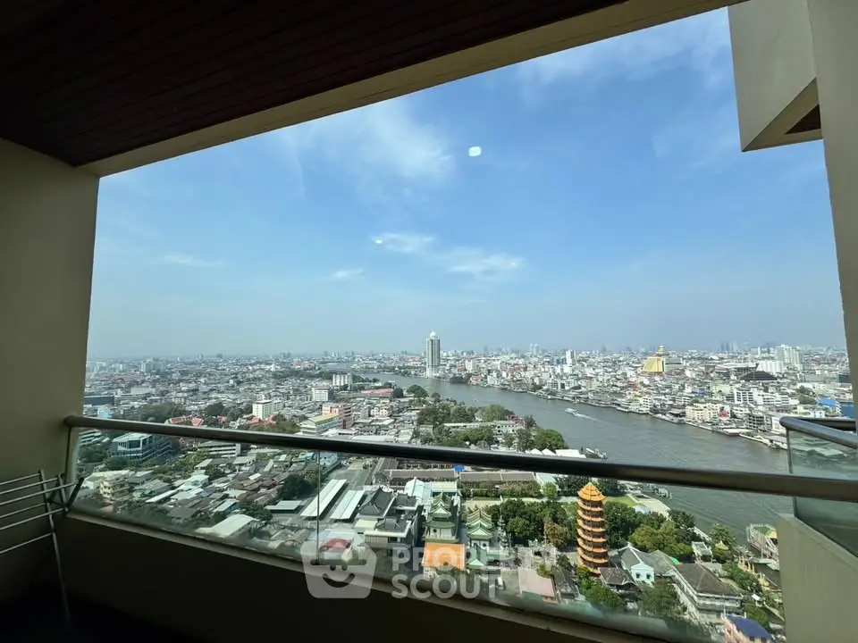 Stunning high-rise balcony view overlooking a vibrant cityscape and river, perfect for urban living.