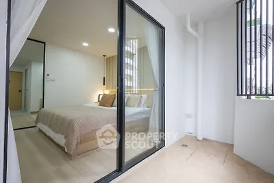 Modern bedroom with glass sliding doors and cozy interior design
