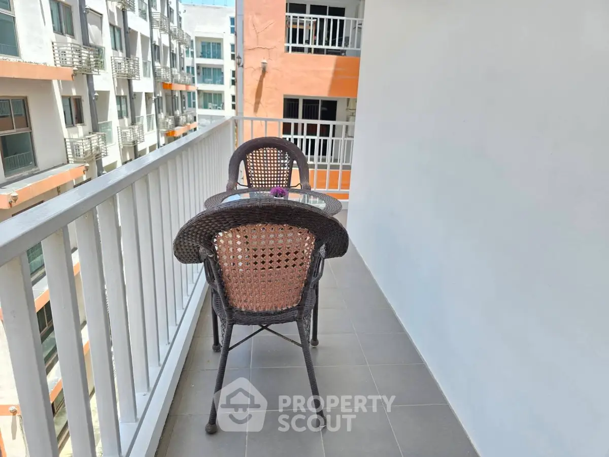 Charming balcony with cozy seating and modern railing, perfect for relaxation.