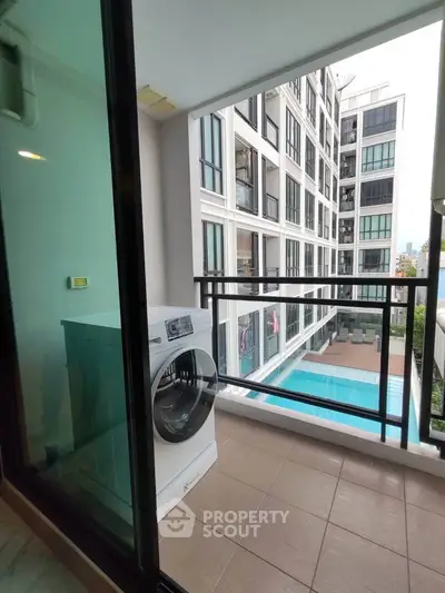 Modern apartment balcony with pool view and washing machine