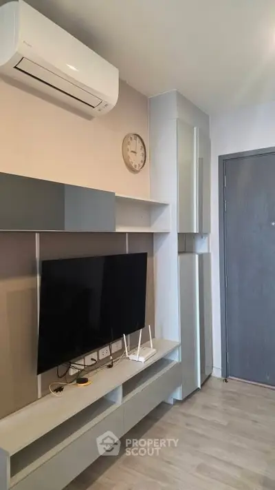 Modern living room with sleek TV unit and air conditioning, perfect for urban living.
