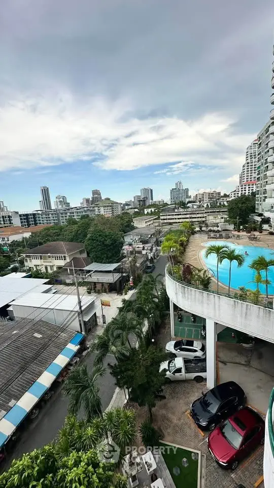 Stunning cityscape view with pool and parking area in a modern residential complex.