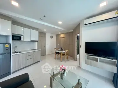 Modern open-plan living room with sleek kitchen and dining area, featuring contemporary furnishings and ample natural light.