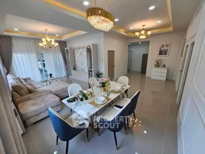 Luxurious open-plan living and dining area with elegant chandelier and modern furnishings.