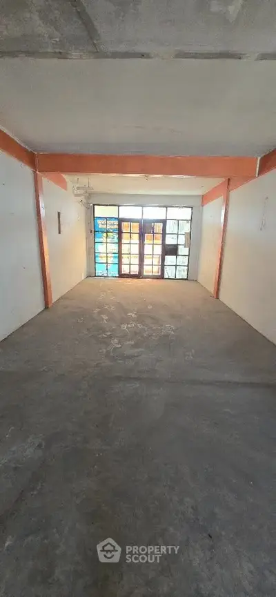 Spacious empty garage with large window and concrete flooring, ideal for storage or parking.