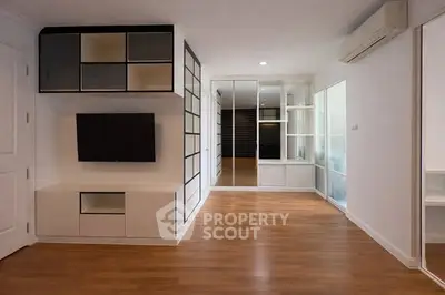 Modern minimalist living room with sleek built-in storage and hardwood floors