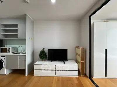 Modern living room with sleek TV stand and compact kitchen area