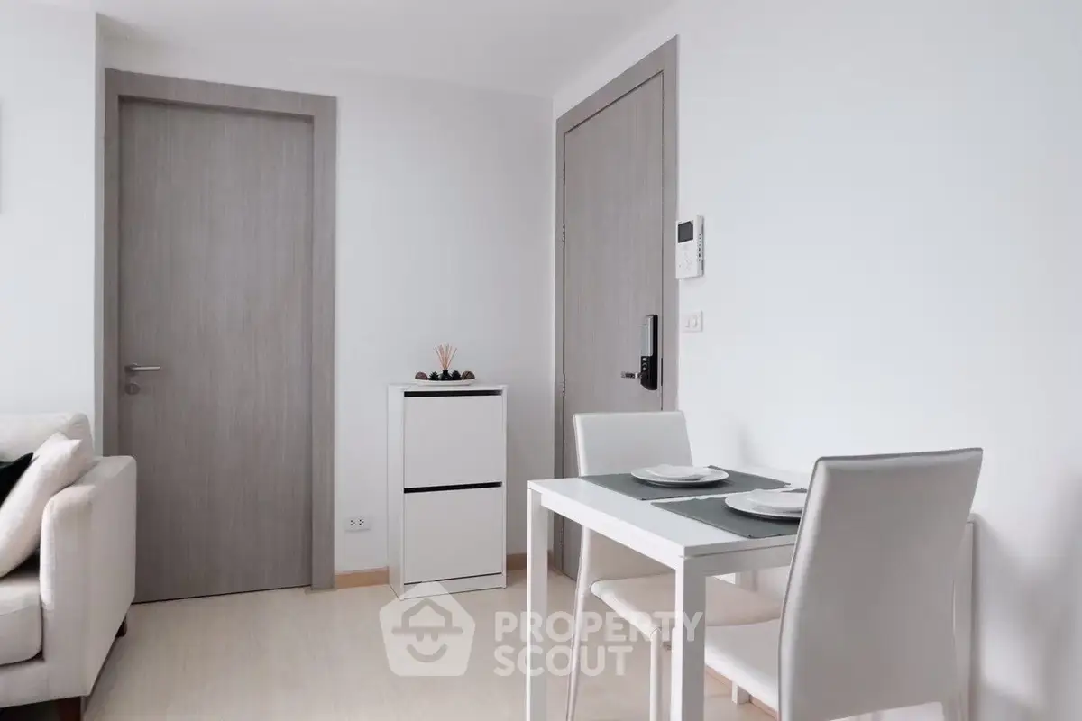 Modern minimalist dining area with sleek white furniture and neutral tones.