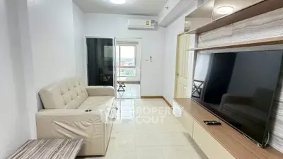 Modern living room with sleek TV unit and comfortable seating in a bright apartment.