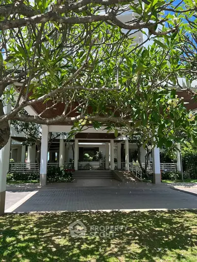 Elegant building entrance with lush greenery and modern architecture